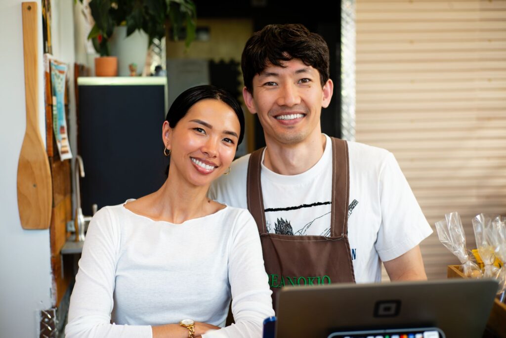 Smiling small business owners behind their shop counter